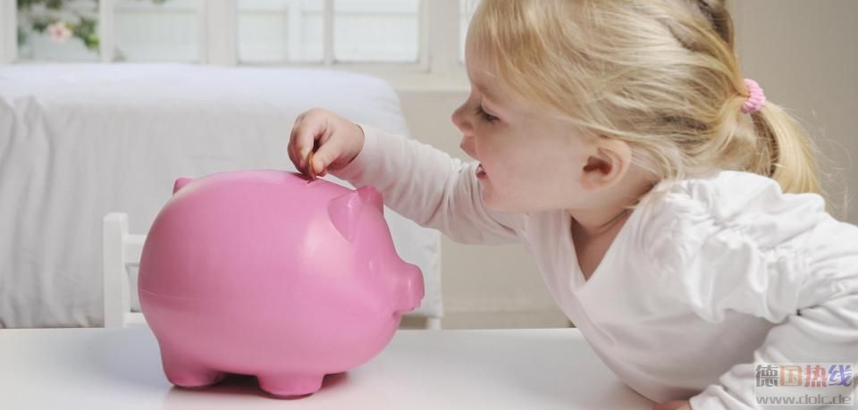 Young-girl-placing-a-coin-in-a-piggy-bank.jpg